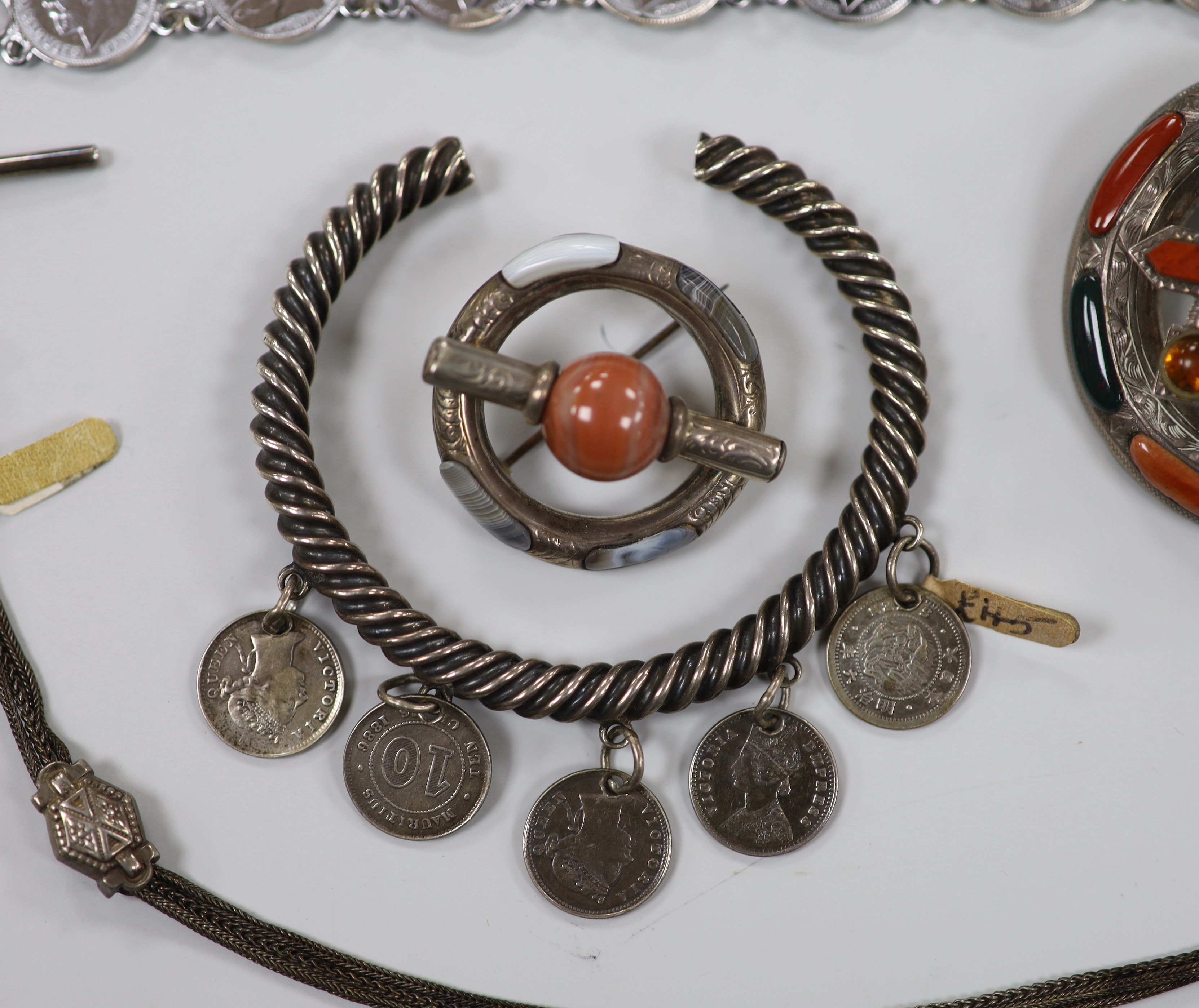 Two white metal and Scottish hardstone set brooches, largest 51mm, two coin set bracelet and a fob chain.
